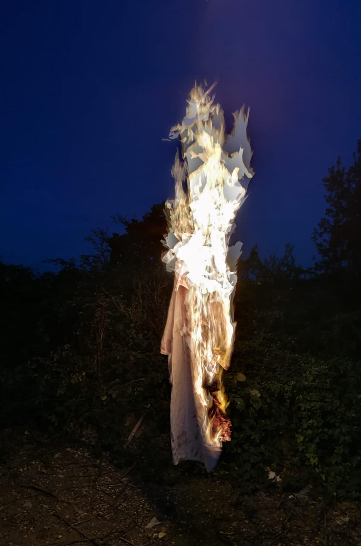 Burning Dress. Photograph of a white muslin dress that I handmade and decorated with paint, embroidery and text and then burned. 2022 Exhibited House of Smalls 2024